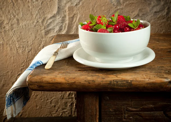 Fruta vermelha em uma velha mesa — Fotografia de Stock