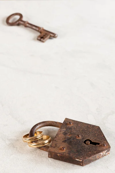 Schlüsselschloss und Eheringe — Stockfoto