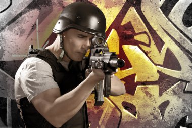 Paintball player on graffiti background with intense orange ligh clipart