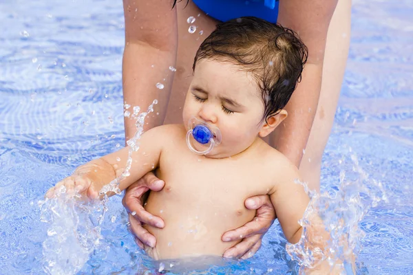 彼の母が付いているプールで遊んでいる生まれたばかりの赤ちゃんの少年 — ストック写真