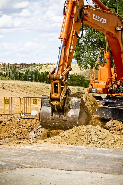 Orange excavator on a road — Stock Photo, Image