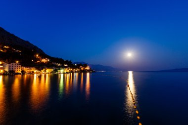 küçük Dalmaçyalı Köyü ve Adriyatik Denizi bay moon tarafından aydınlatılmış