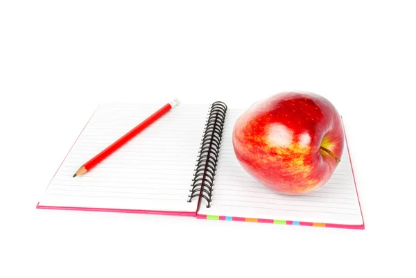 Kırmızı elma ve oturma üstünde açılan bir defter kalem
