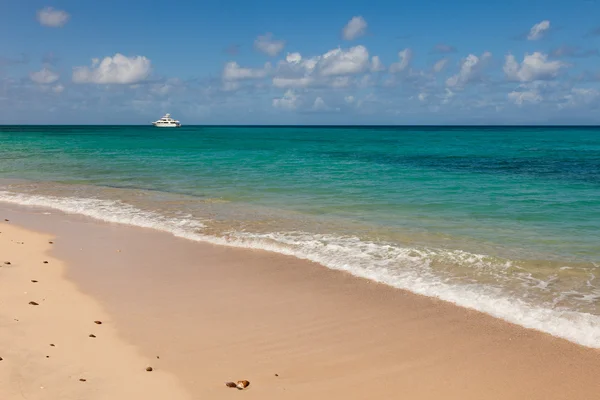 Tropische Caribisch strand zeegezicht met motorjacht zeilen in — Stockfoto