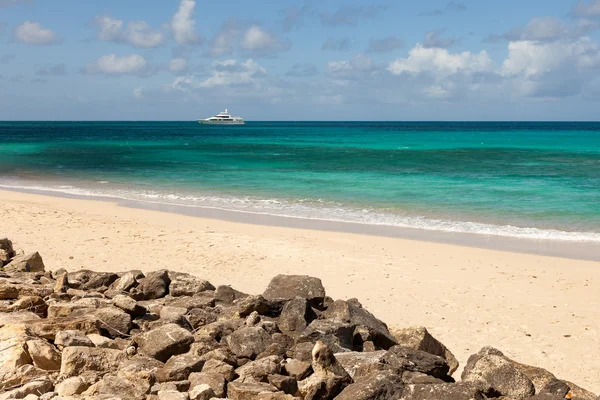 Tropische Caribisch strand zeegezicht met motorjacht en blauwe hemel — Stockfoto
