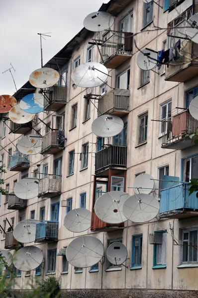 Viele Satellitenschüsseln an der Wand. — Stockfoto