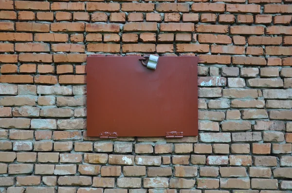 Brick wall with a closed metal hatch. — Stock Photo, Image