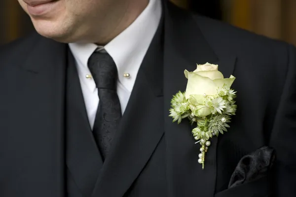 Άνθρωπος με μαύρο κοστούμι με άσπρο τριαντάφυλλο κουμπότρυπα — Φωτογραφία Αρχείου