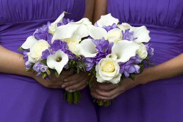 Bruidsmeisjes met bruiloft boeketten — Stockfoto