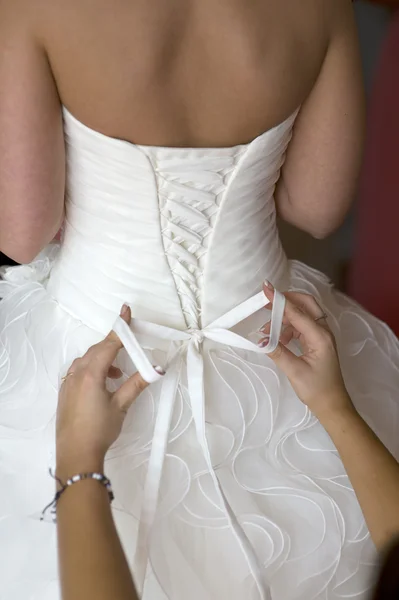 Binden der Schleife an einem Brautkleid — Stockfoto