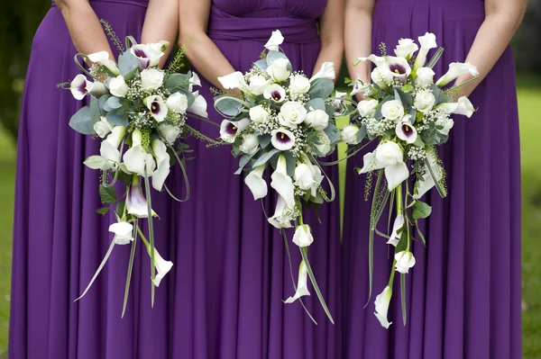 Trois demoiselles d'honneur tenant des bouquets de mariage — Photo