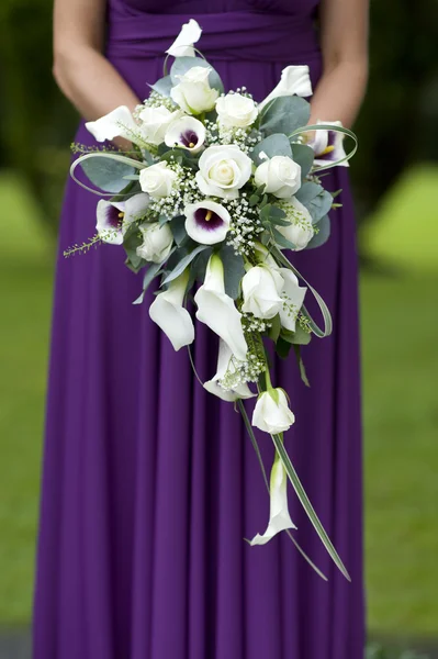 Bruidsmeisje in paars met bruiloft boeket — Stockfoto