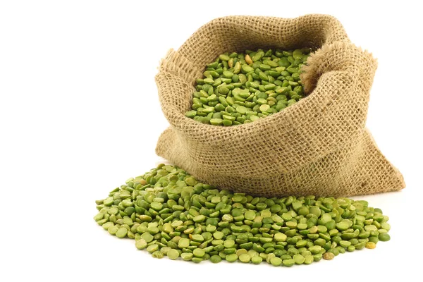 黄麻布の袋で緑色のエンドウ豆を分割します。 — ストック写真