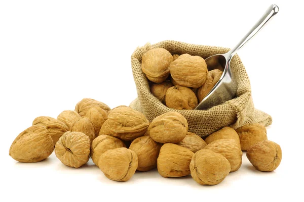 Čerstvé vlašské ořechy pytlovina pytle s kovovou kopeček — Stock fotografie