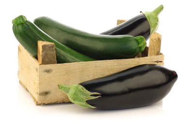 Fresh zucchini's and eggplant in a wooden box clipart