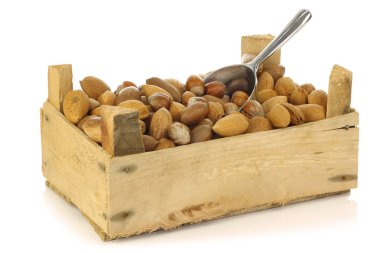 Assorted nuts in a wooden box with an aluminum scoop clipart