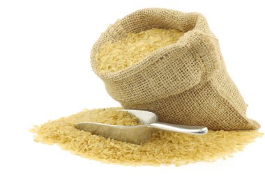 Unpolished rice (whole grain) in a burlap bag clipart