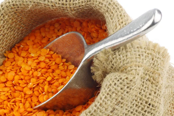 Red lentils in a burlap bag with a metal scoop — Stock Photo, Image