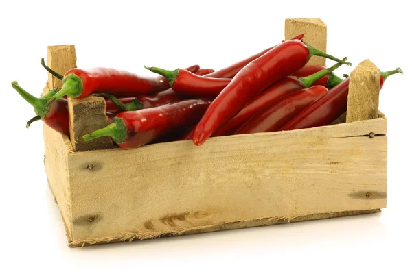 Verse rode chilipepers in een houten krat — Stockfoto