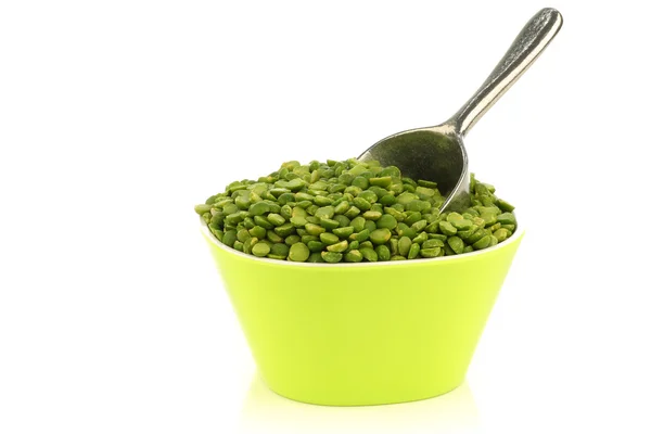 Pecah kacang polong hijau dalam mangkuk hijau dengan sendok aluminium — Stok Foto