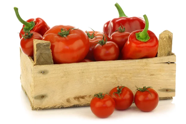 Pimentas vermelhas doces e tomates em uma caixa de madeira — Fotografia de Stock
