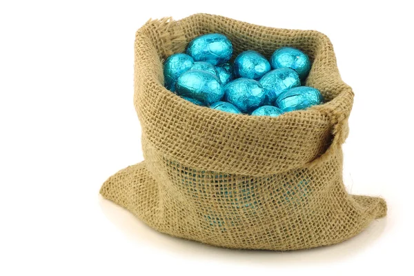 Coloridos huevos de Pascua de chocolate en una bolsa de arpillera — Foto de Stock