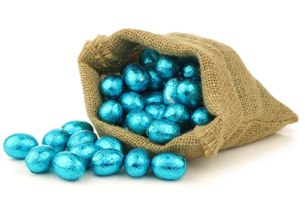 Colorful chocolate easter eggs in a burlap bag — Stock Photo, Image