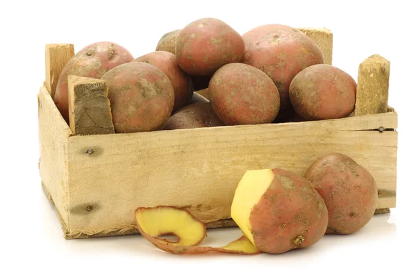 Frisch geerntete holländische Kartoffeln namens "bildtstar" und eine geschälte Kartoffel in einer Holzkiste — Stockfoto