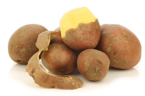 Φρεσκοκομμένου ολλανδική πατάτες που ονομάζεται "bildtstar" και ένα αποφλοιωμένες — Φωτογραφία Αρχείου