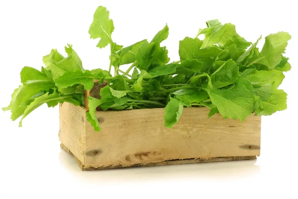 Fresh turnip tops (turnip greens) in a wooden crate — Stock Photo, Image
