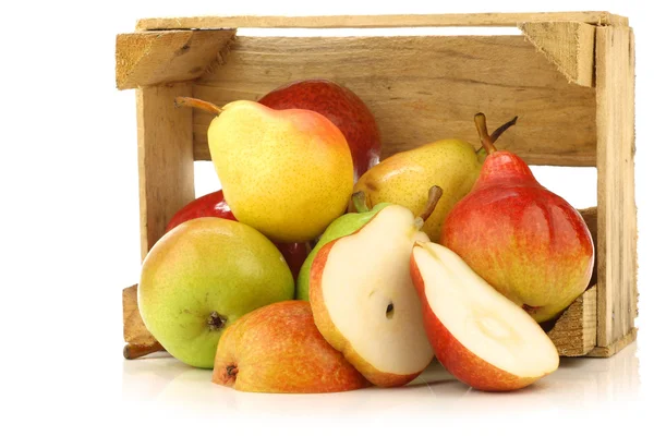 Assortment of different colorful pears and a cut one in a wooden crate — Stock Photo, Image