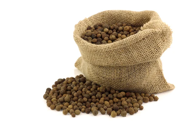 Especiarias secas (pimenta da Jamaica) em um saco de serapilheira — Fotografia de Stock