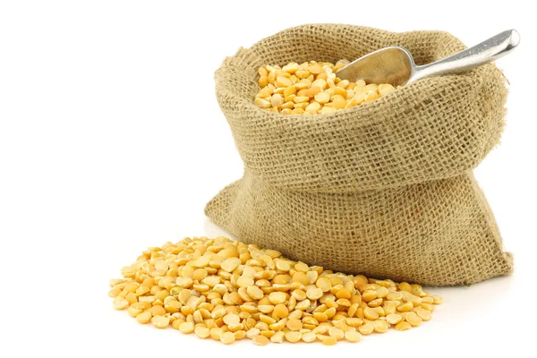 Yellow split peas in a burlap bag with an aluminum scoop — Stock Photo, Image