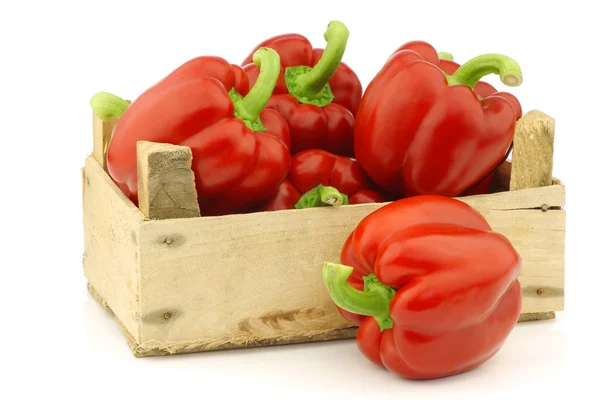 Fresh red bell peppers (capsicum) in a wooden crate — Stock Photo, Image