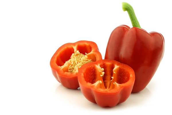 Fresh red bell pepper (capsicum) and a cut one — Stock Photo, Image