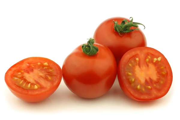 Tomates frescos y uno cortado — Foto de Stock