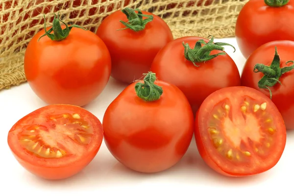 Fresh tomatoes and a cut one — Stock Photo, Image