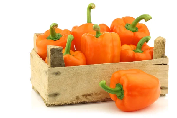 Fresh orange bell peppers in a wooden crate — Stock Photo, Image
