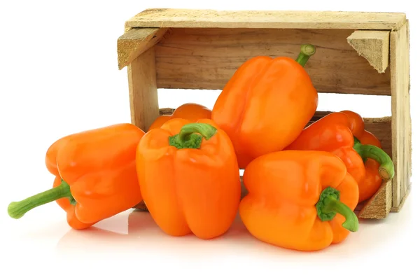 Fresh orange bell peppers in a wooden crate — Stock Photo, Image