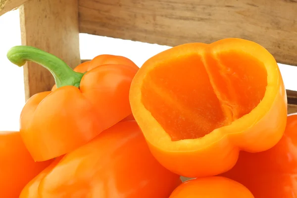 Frische orangefarbene Paprika und eine geschnittene — Stockfoto