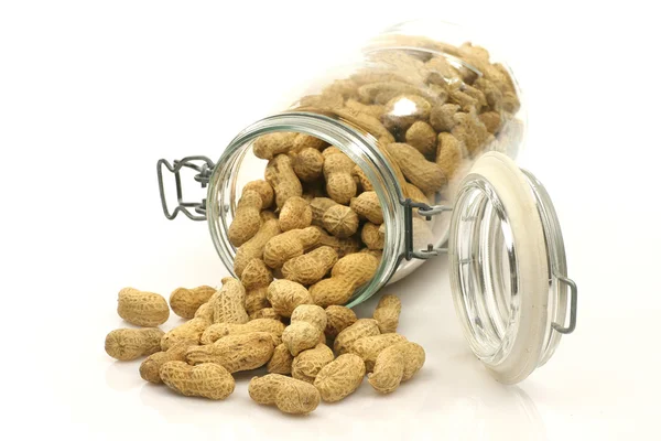 Glass bottle with lots of peanuts — Stock Photo, Image
