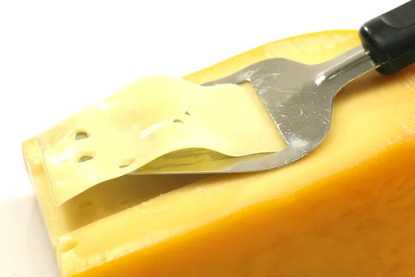 Szeletelés keresztül egy blokk sajt sajt szeletelő — Stock Fotó