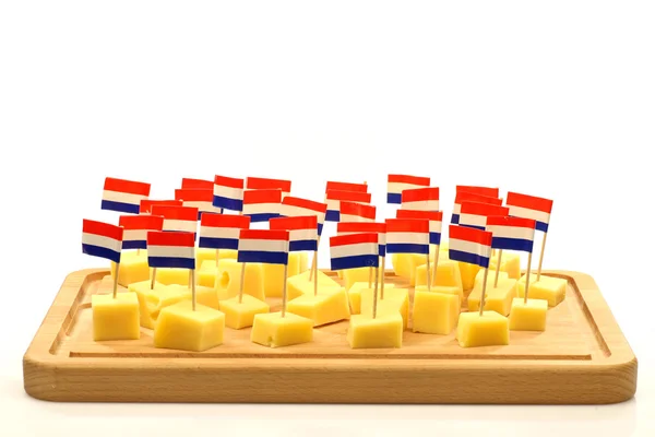 Блоки голландского сыра на деревянном подносе с голландскими зубочистками под флагом — стоковое фото