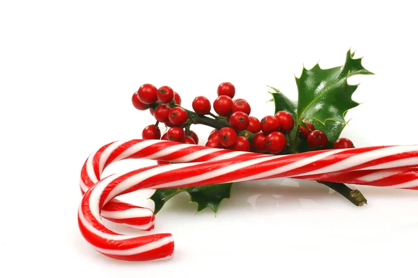 Christmas candy canes with a branch of holly — Stock Photo, Image