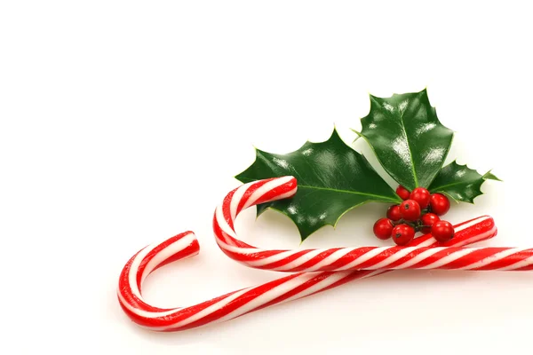 クリスマスのキャンディの杖はヒイラギの枝を持つ — ストック写真
