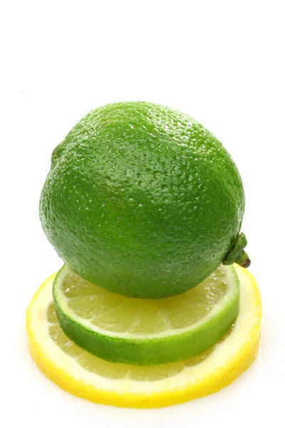 Целый лимонный фрукт поверх ломтика лайма и лимона — стоковое фото