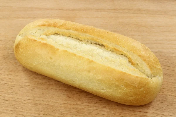Pão fresco em uma placa de corte de madeira — Fotografia de Stock