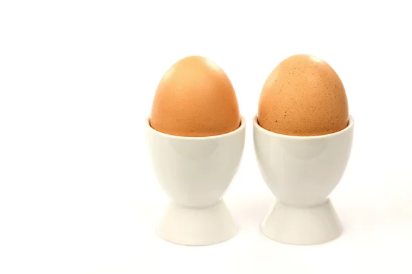 Two white egg cups with brown eggs — Stock Photo, Image
