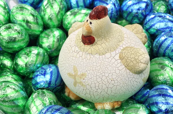 Ceramic easter chicken sitting on colorful easter eggs — Stock Photo, Image