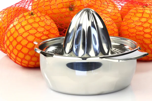 Citrus press with a net full of fresh oranges — Stock Photo, Image